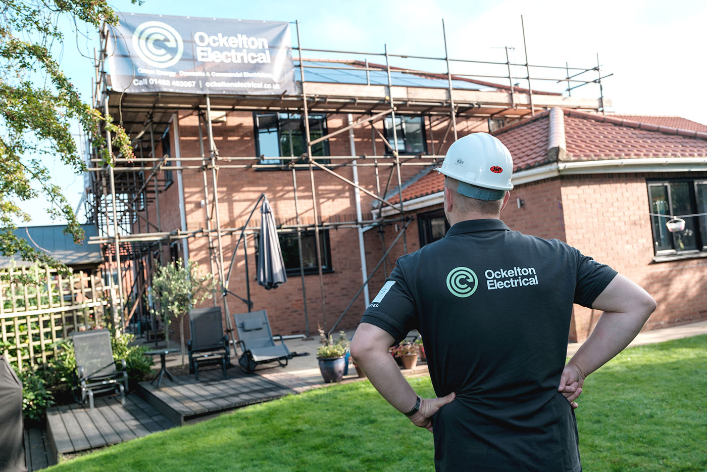 Ockelton Electrical worker looking at a house with scaffolding